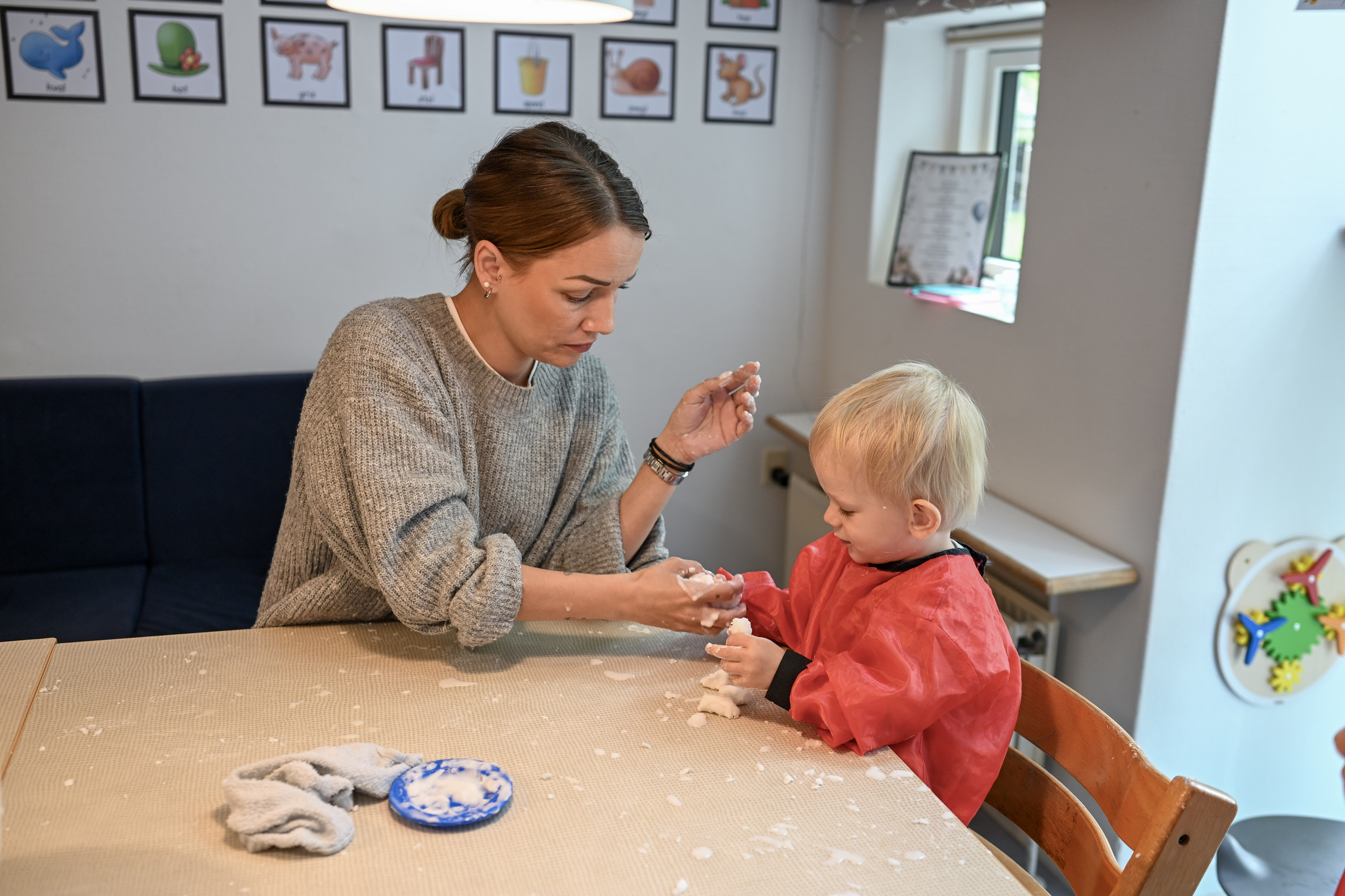Voksen og barn leger med dej på et bord